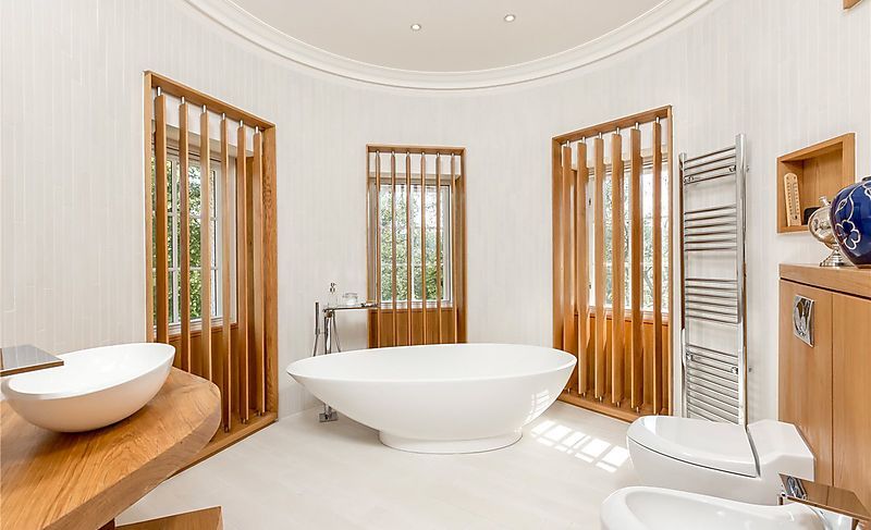white bathtub in middle of room with 3 windows surrounding
